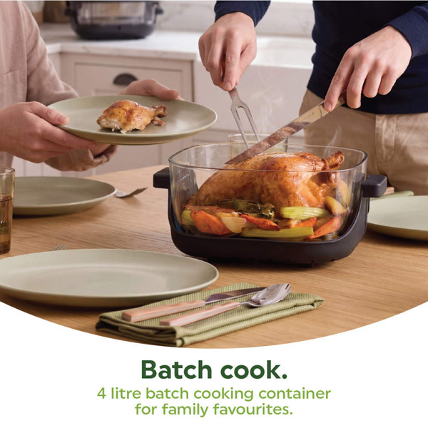Clear 4 litre cooking container holding roast chicken and veg, served at family dining table.