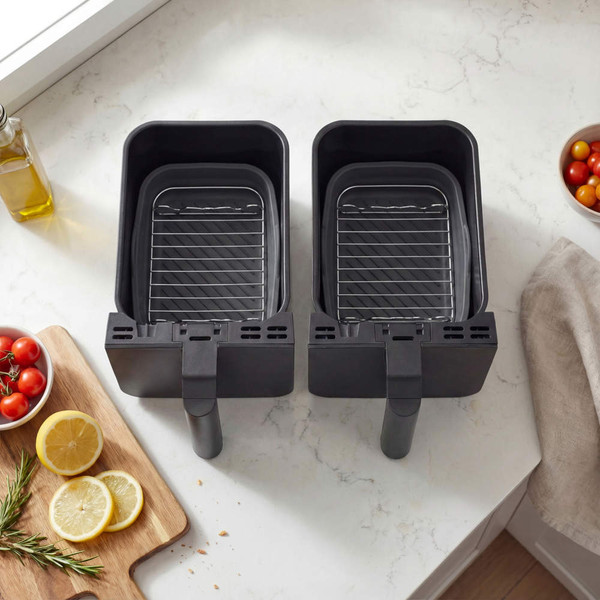Grey dual air fryer baskets with racks shown empty on kitchen counter