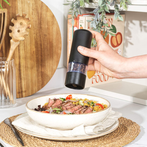 Black electric pepper mill seasoning grilled beef salad