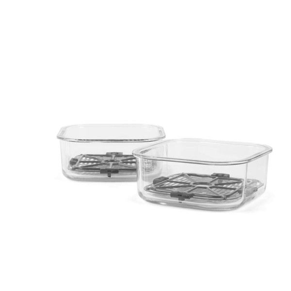 Glass lunch container with vegetables being packed into tan handbag on kitchen counter