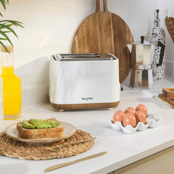 White two-slice toaster with wood accents on kitchen counter, shown with eggs and toast
