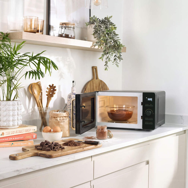 Black and silver microwave with digital display on kitchen counter
