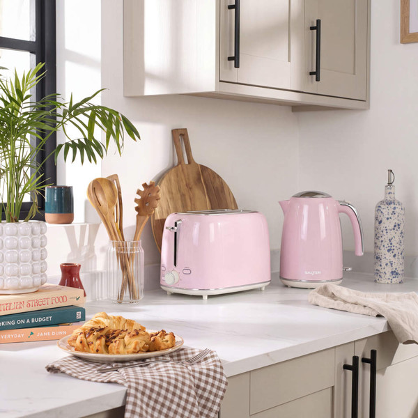 Pink electric kettle with water level indicator and chrome handle, side view