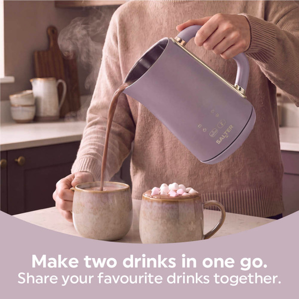 Person pouring hot chocolate from a mauve kettle into mugs