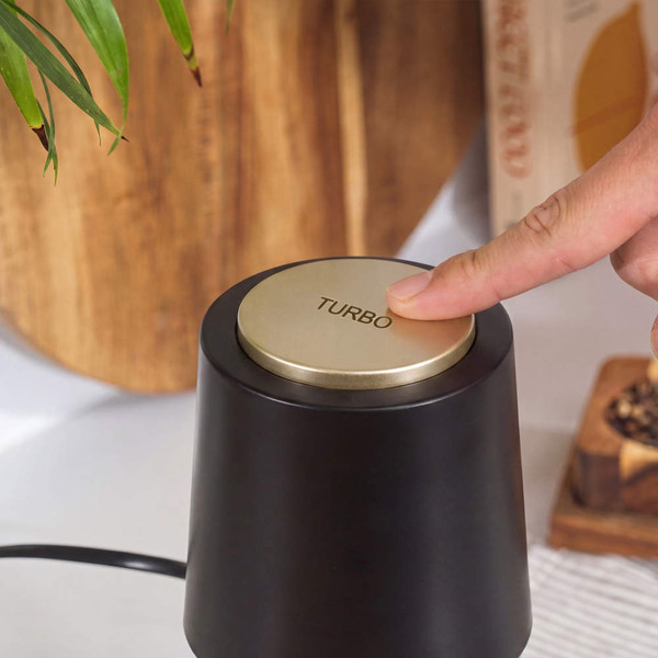 Black and gold appliance with turbo button being pressed