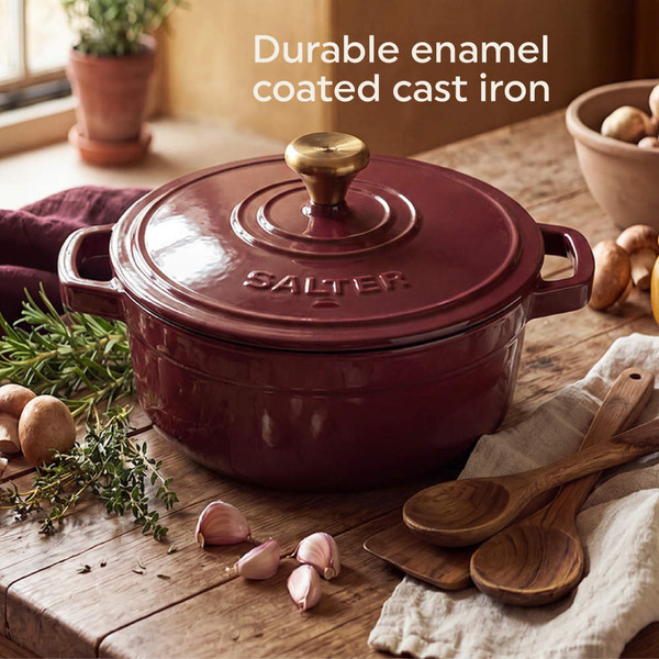 Red cast iron casserole dish with gold knob on wooden board