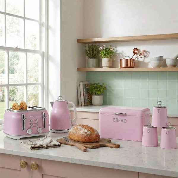 Kitchen scene with pastel pink toaster, kettle, bread bin and canisters on worktop