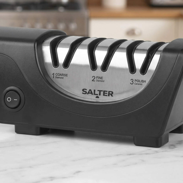 Electric knife sharpener with three sharpening slots on kitchen worktop