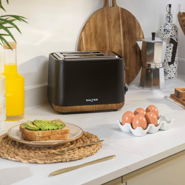 Black two-slice toaster with wood trim on kitchen counter, styled for home use