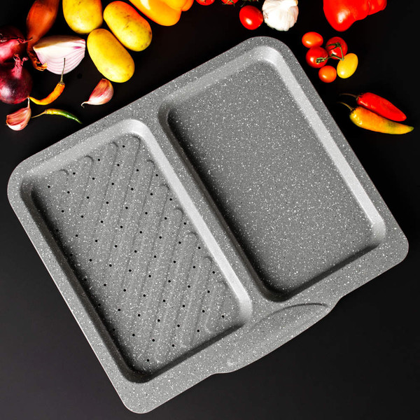 Grey double roasting tray with perforated section, shown top-down with fresh vegetables.