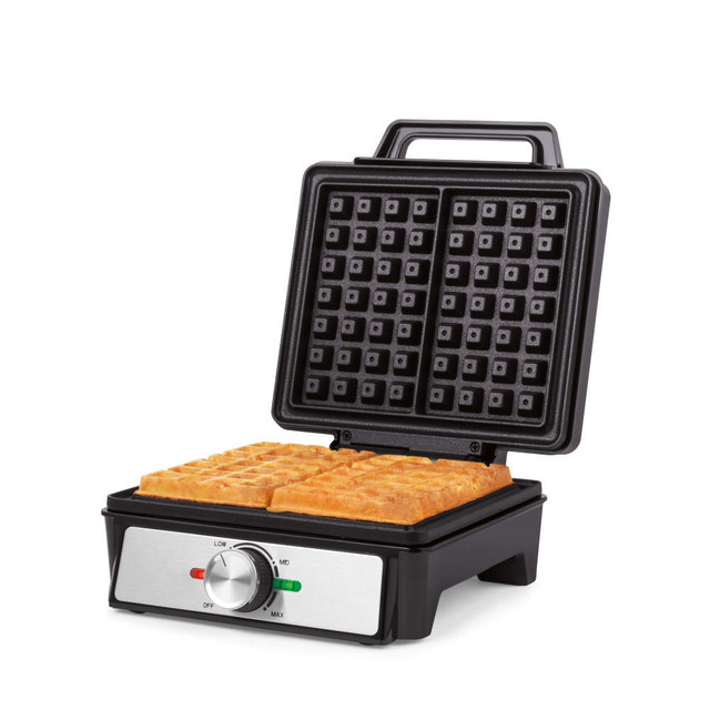 Black waffle maker with two golden waffles, lid open, showing temperature dial