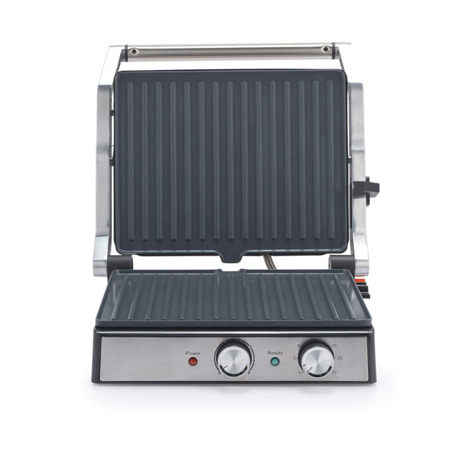 Silver electric grill and panini press with open lid, showing ridged plates and control dials
