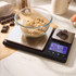 Digital kitchen scale with bowl of brown sugar and chocolate pieces, shown on worktop