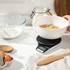 White digital kitchen scale with a bowl of fresh strawberries on display