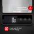 Digital kitchen scale with large backlit display and buttons for switching units.