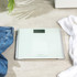 White digital bathroom scale showing close-up of kg LCD display, reading zero
