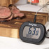 Digital meat thermometer showing 63°C for beef, next to sliced roast beef on chopping board