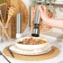 Stainless steel electric salt and pepper grinders in use over a salad bowl