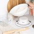 White mechanical kitchen scale weighing flour in a bowl on countertop