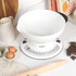 White kitchen scale with large bowl on worktop, shown for baking preparation.