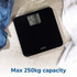 Black digital bathroom scale on tiled floor, near jeans and white towel