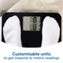 Person in light trainers and jeans standing on digital bathroom scale