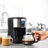 Black and silver filter coffee machine with glass jug in modern kitchen setting