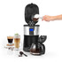 Salter coffee maker in black and silver, lid open, adding beans, glass mug of layered coffee beside.