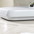 White mechanical bathroom scale angled on tiled floor
