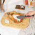 Person carving roast chicken breast on a bamboo chopping board