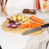 Chopping board with sliced red onion, potatoes, carrots and Salter chef’s knife
