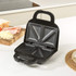 Black geometric Salter sandwich maker with rose gold detail, shown beside plate of toasted sandwiches.