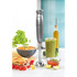 Silver handheld stick blender shown upright with soup and vegetables on kitchen worktop
