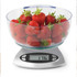 Clear bowl of fresh strawberries on digital kitchen scale displaying 176 grams