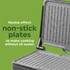 Black panini press toasting sandwich with tomato, cheese, and basil, lid partially closed