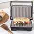 Grey electric grill with open non-stick plates and removable drip tray