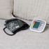 Automatic blood pressure monitor with arm cuff on a sofa