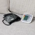 Automatic blood pressure monitor with arm cuff on a sofa