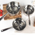 Set of three stainless steel saucepans with lids stacked on a kitchen hob