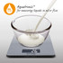 Digital kitchen scale weighing milk in a glass bowl, showing Aquatronic liquid measurement feature.