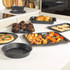 Set of grey speckled non-stick baking trays and tins displayed with baked goods
