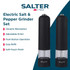 Black electric pepper grinder dispensing onto steak salad, with matching salt mill beside