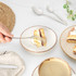 Stainless steel knife, fork, and spoons set on beige plate with woven placemat