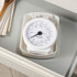 White mechanical kitchen scale on worktop beside flour, eggs and cookbooks