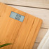 Bamboo digital bathroom scale with clear display, shown on light wooden floor