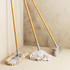Set of three cleaning tools: floor mop, string mop and broom with wooden handles.