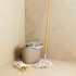 Beige mop and bucket set with wooden handle, plus bag of wooden pegs on cream floor
