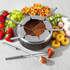 Raclette pans with mixed toppings, cheese and cured meats for tabletop serving.