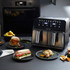 Black Salter dual air fryer with digital display, shown on kitchen counter with plated food.