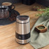 Stainless steel electric grinder filled with dried red chillies on kitchen worktop